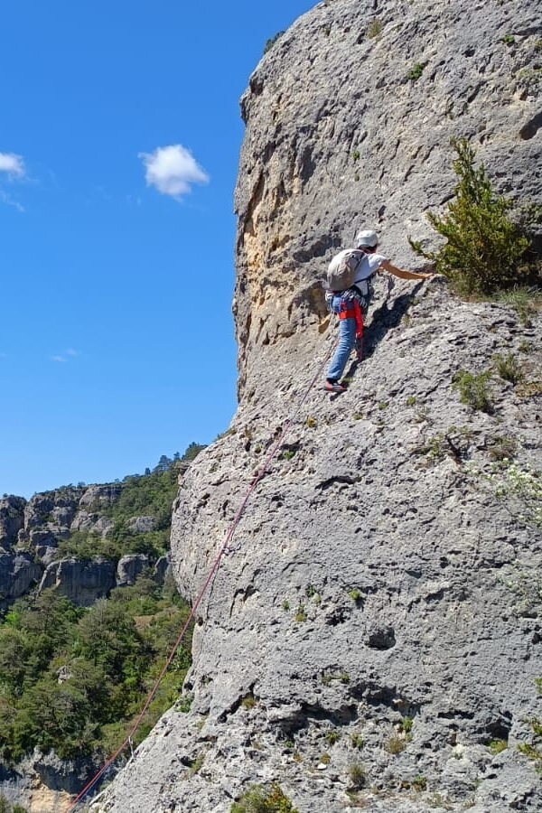 Photo d'un grimpeur Adrénaline Escalade sur une falaise avec un beau ciel bleu